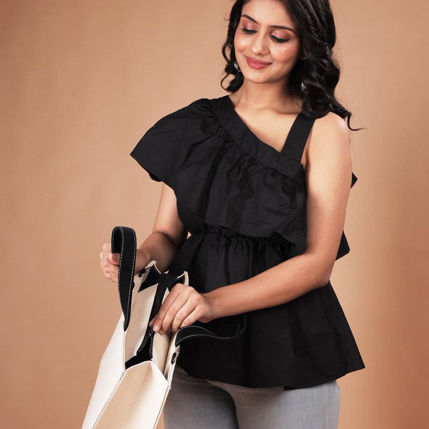 Woman holding a beige handbag against a brown background
