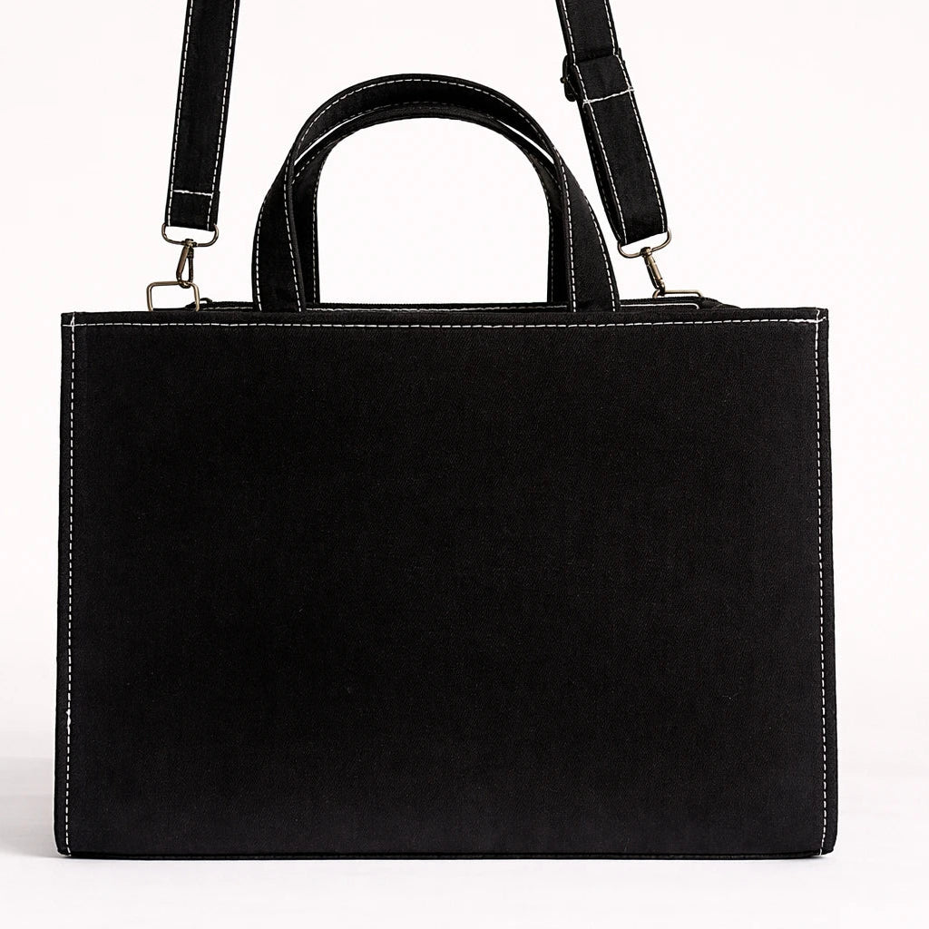 Black leather handbag with a shoulder strap on a white background