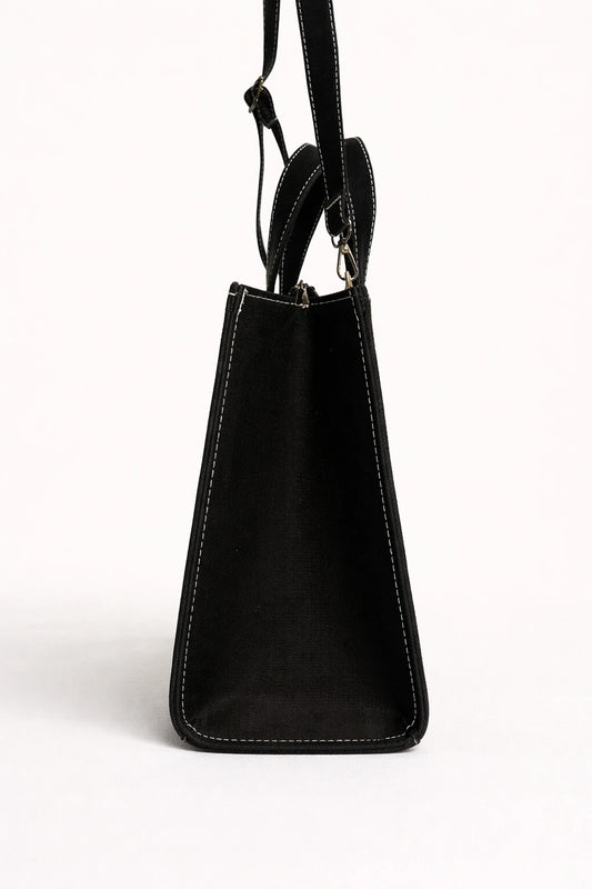 Black leather handbag with a strap on a white background