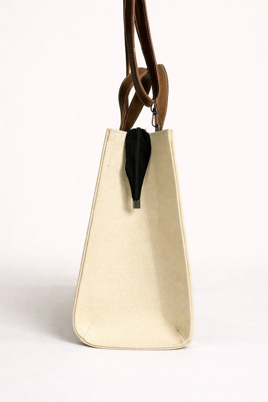 Beige handbag with a black feather detail on a white background