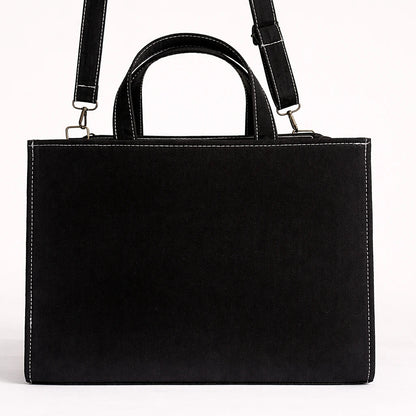 Black leather handbag with a shoulder strap on a white background
