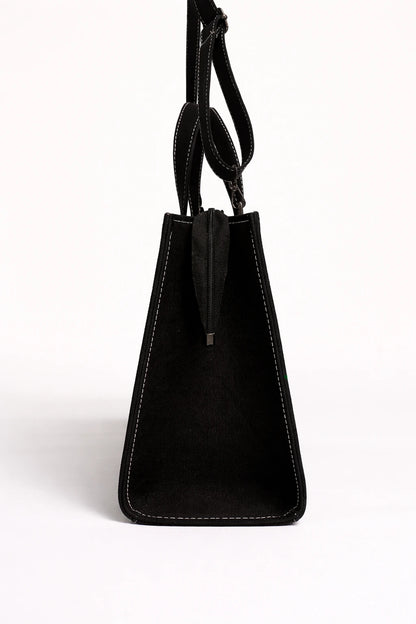 Black handbag with a strap on a white background