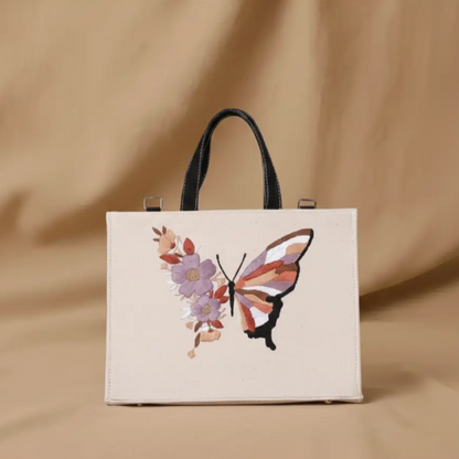 Beige tote bag with butterfly and floral design on a beige background