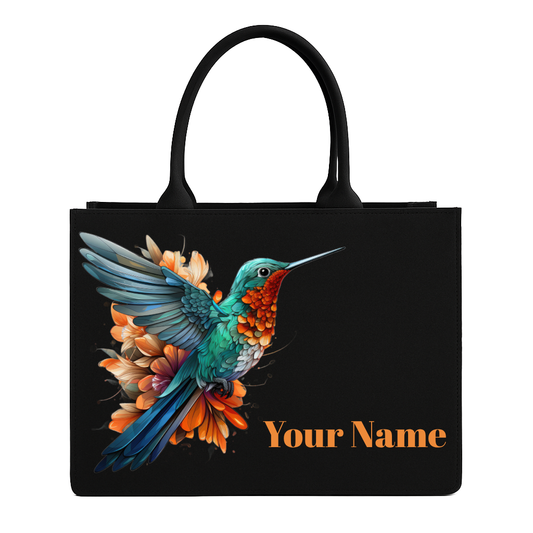 Black tote bag with a colorful hummingbird design and space for personalization on a white background