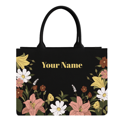 Black tote bag with floral design and space for personalization on a white background