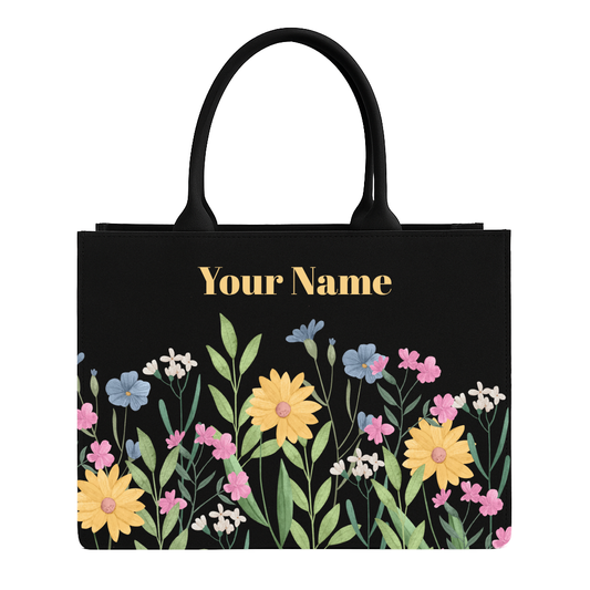 Black tote bag with floral design and space for personalization on a white background
