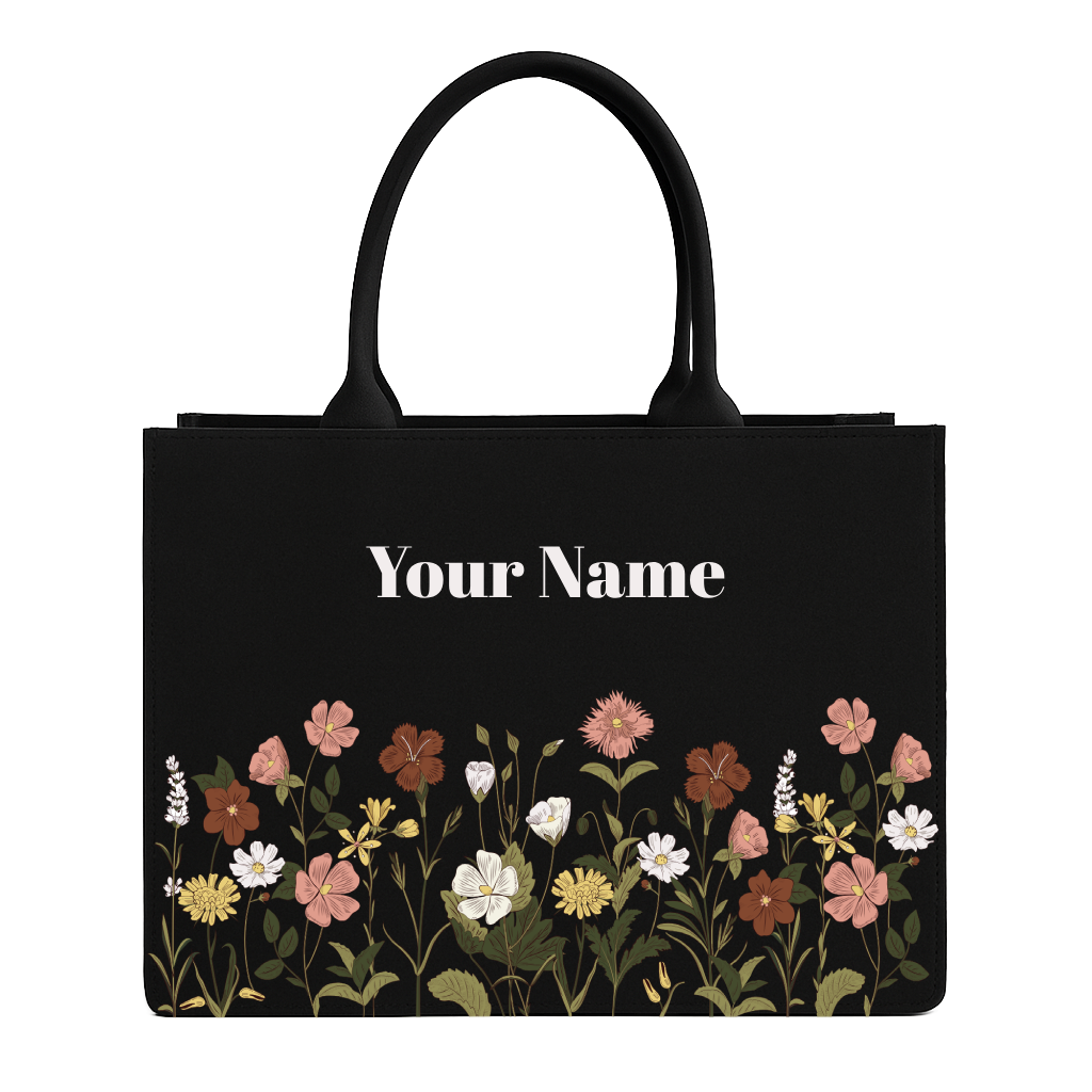 Black tote bag with floral design and space for personalization on a white background