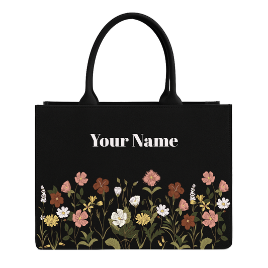 Black tote bag with floral design and space for personalization on a white background
