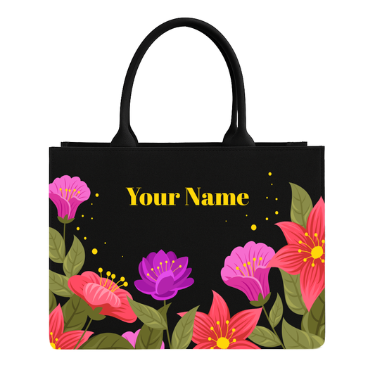 Black tote bag with colorful floral design and 'Your Name' text on a white background