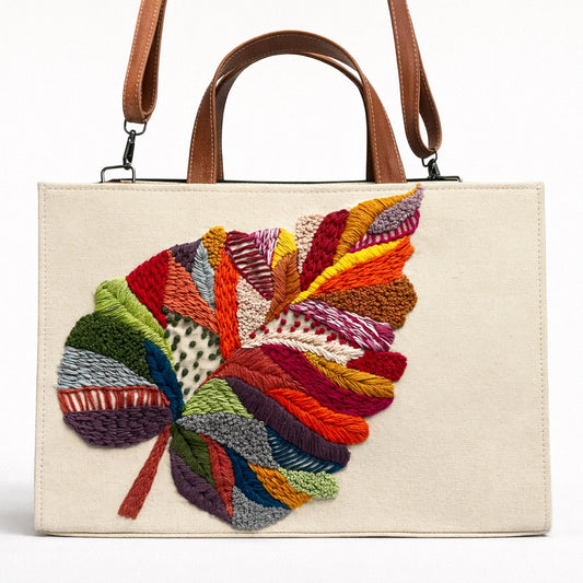 Handbag with a colorful leaf design on a white background