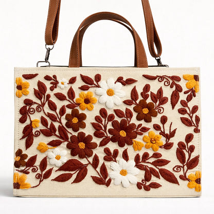 Handbag with floral embroidery design on a white background